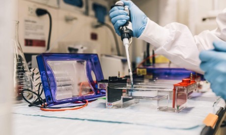 scientist in lab with pipette scaled