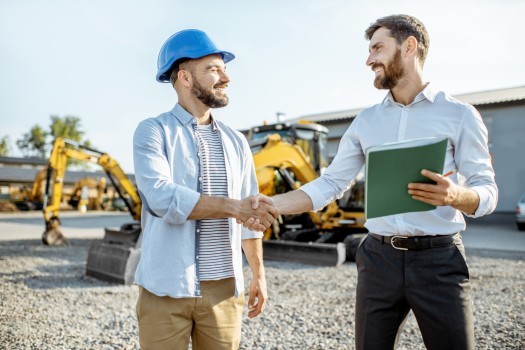 Builder choosing heavy machinery for construction with a sales consultant 